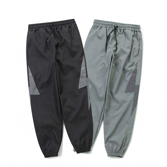 Los hombres al por mayor del fabricante del OEM sueltan los pantalones personalizados de nylon reflexivos de la cazadora del logotipo de encargo de los pantalones ocasionales